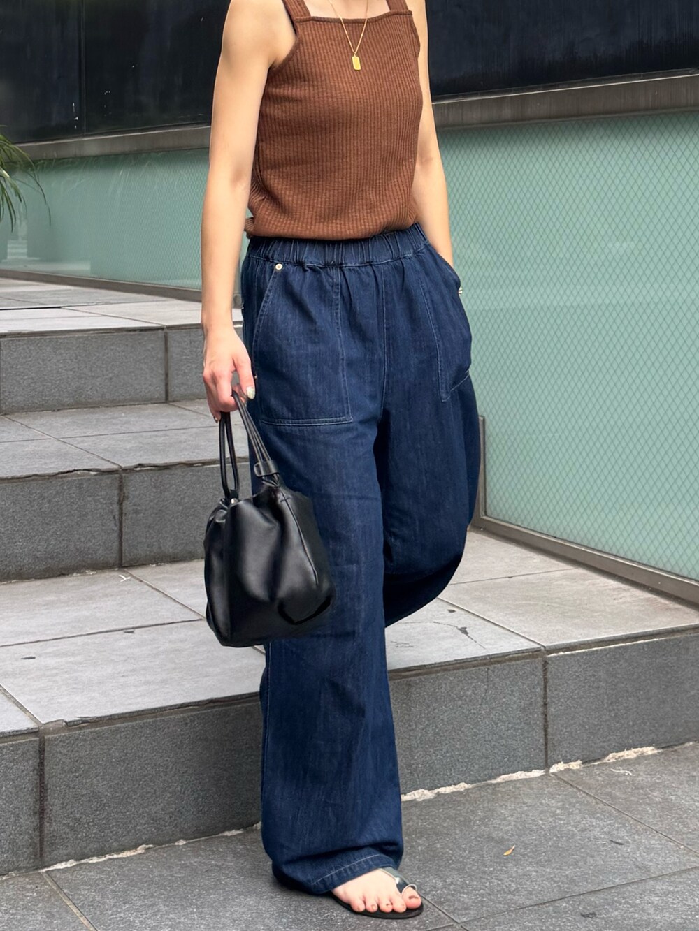 ブラウン系のTシャツ/カットソー、ブルー系のデニムパンツを着用したレディースの夏コーディネートの4枚目の写真