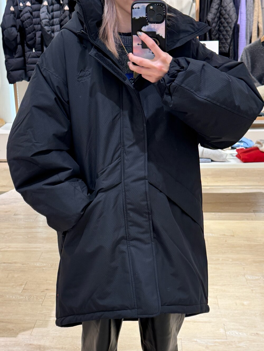 ブラック系のダウンジャケット/コート、ブルー系のキャップを着用したレディースの秋コーディネートの2枚目の写真