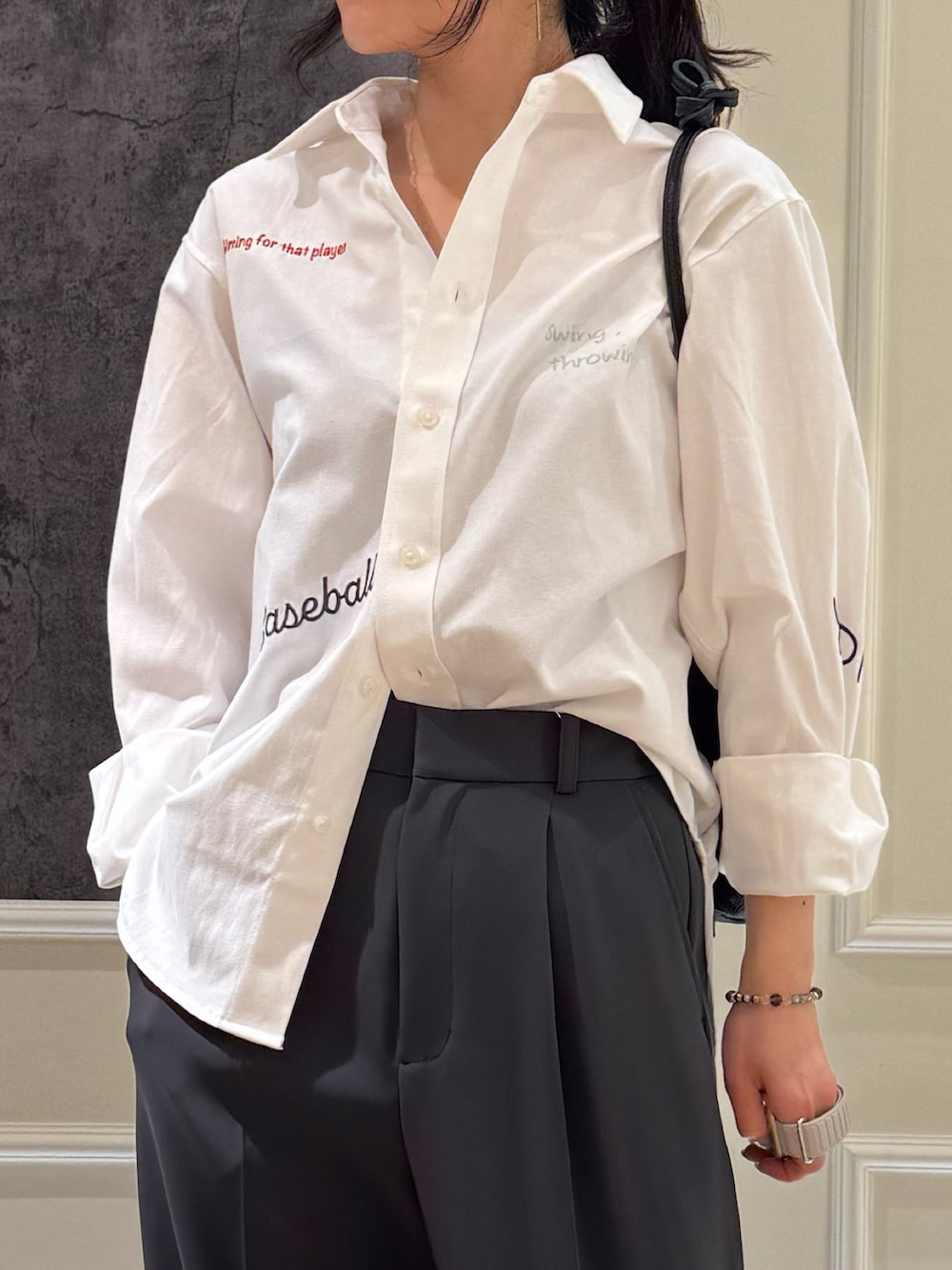 ホワイト系のシャツ/ブラウス、グレー系のスラックス、ブラック系のショルダーバッグを着用したレディースの春コーディネートの4枚目の写真