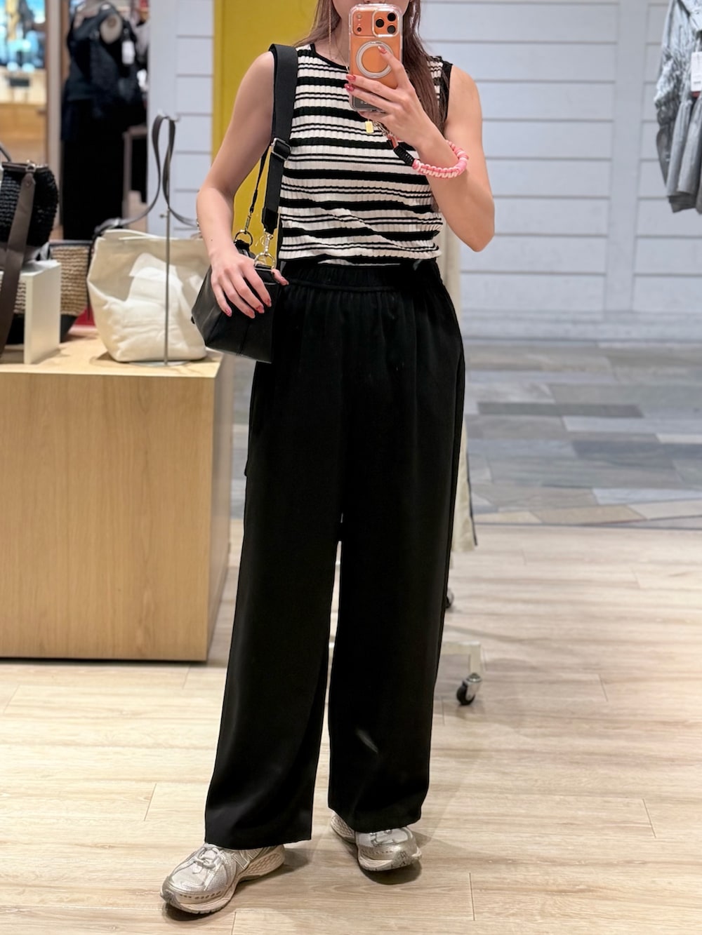 ブルー系のニット/セーター、ブラック系のその他パンツ、ブラック系のショルダーバッグを着用したレディースの夏コーディネートの4枚目の写真
