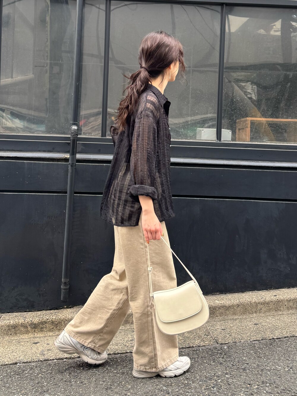 ブラック系のシャツ/ブラウス、ベージュ系のデニムパンツを着用したレディースの春コーディネートの3枚目の写真