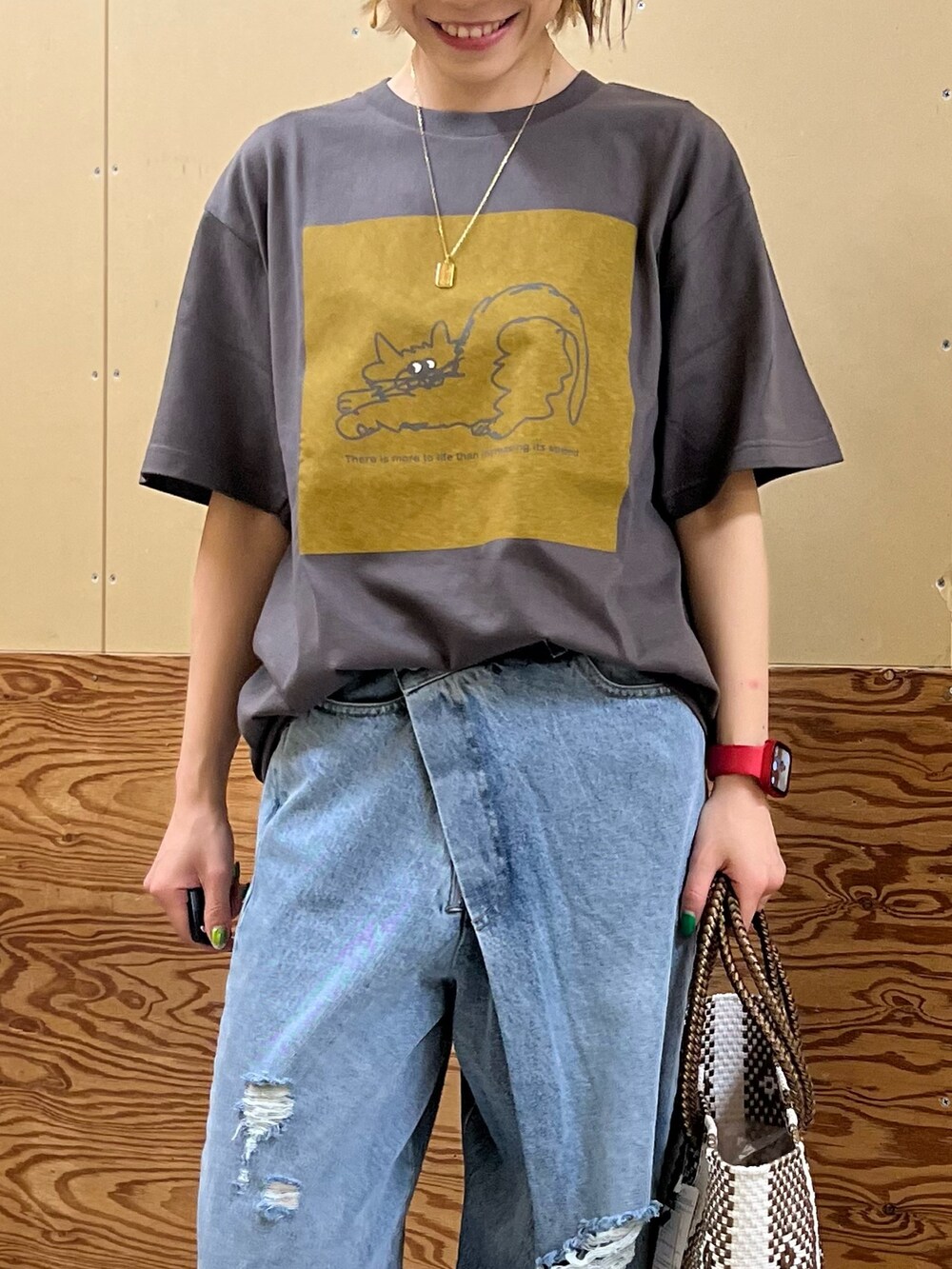 グレー系のTシャツ/カットソー、ブルー系のデニムパンツ、ブラック系のかごバッグを着用したレディースの夏コーディネートの2枚目の写真