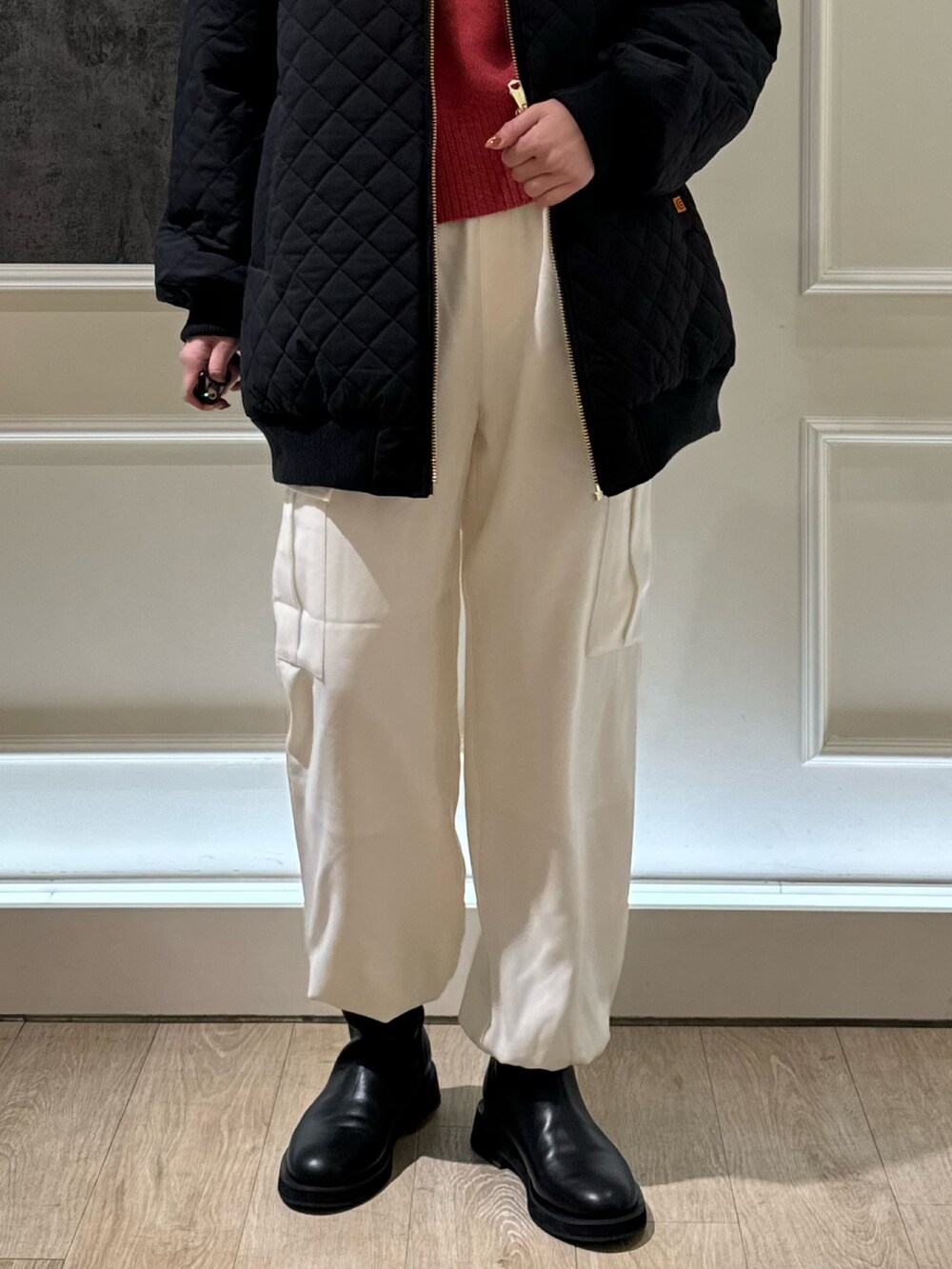 ブラック系のブルゾン、ホワイト系のカーゴパンツ、ピンク系のニット/セーターを着用したレディースの冬コーディネートの3枚目の写真