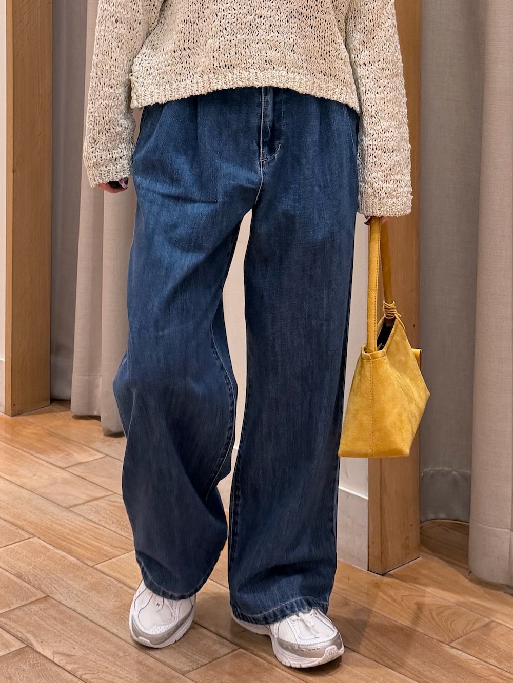 ピンク系のニット/セーター、ブルー系のデニムパンツ、イエロー系のショルダーバッグを着用したレディースの春コーディネートの4枚目の写真