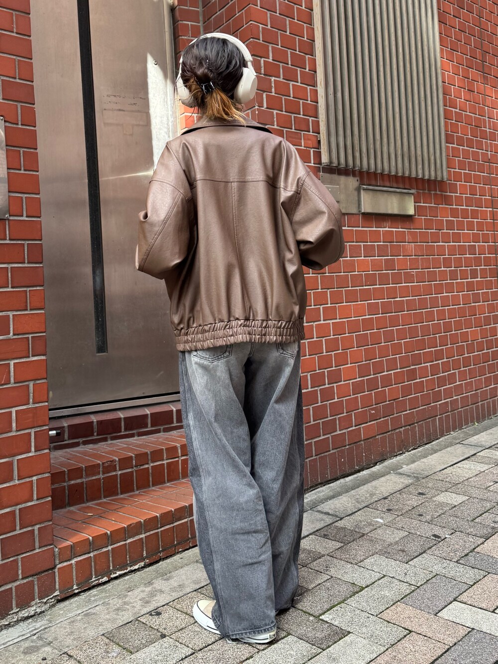ブラウン系のブルゾンを着用したレディースの秋コーディネートの2枚目の写真