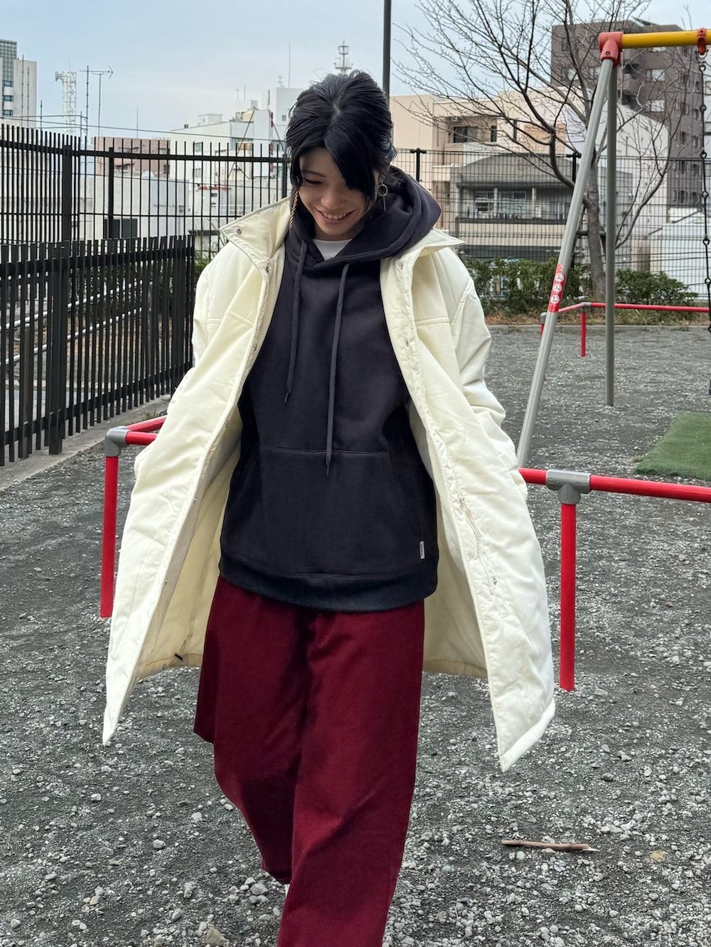 グリーン系のモッズコート、ベージュ系のパーカーを着用したレディースの冬コーディネートの2枚目の写真