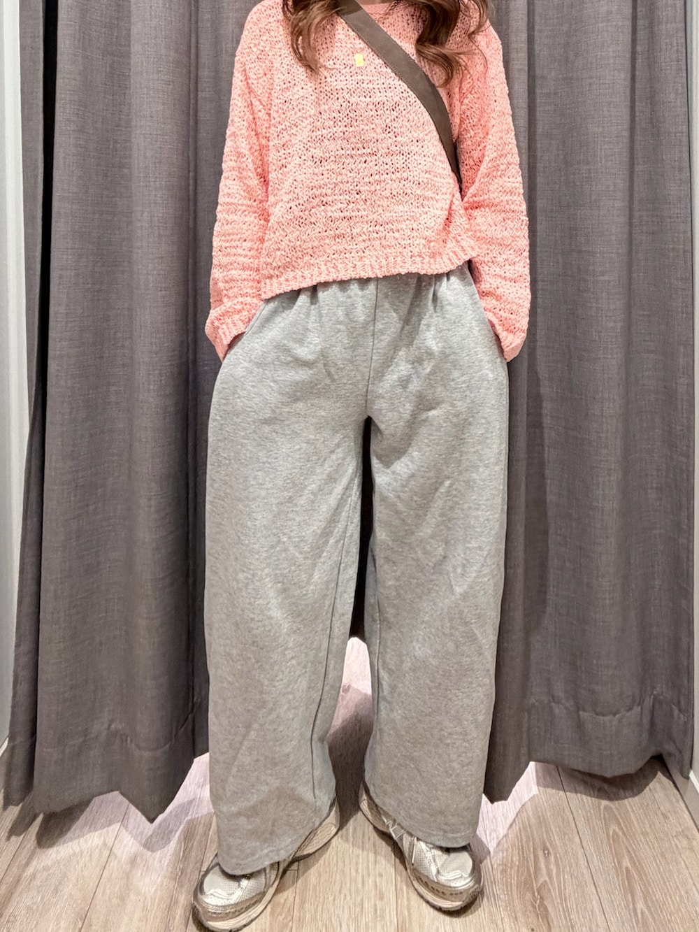 ベージュ系のショルダーバッグ、ピンク系のニット/セーターを着用したレディースの春コーディネートの2枚目の写真