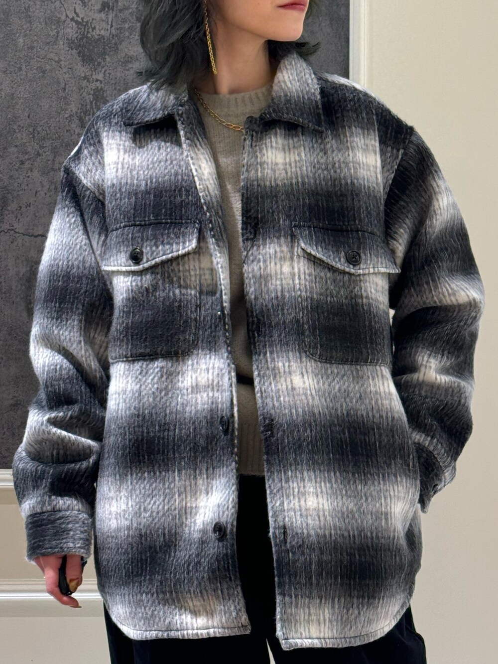 ブラック系のブルゾン、ホワイト系のその他パンツ、ベージュ系のニット/セーターを着用したレディースの冬コーディネートの2枚目の写真