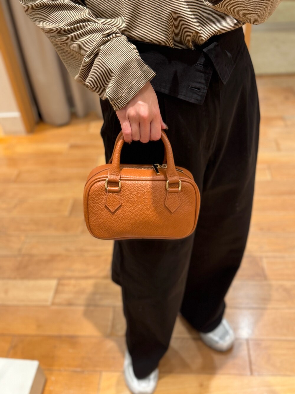 ホワイト系のTシャツ/カットソー、ブラック系のチノパンツを着用したレディースの秋コーディネートの4枚目の写真