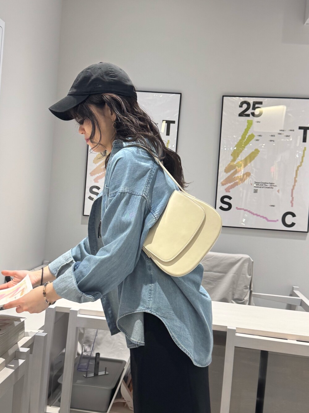 ブルー系のシャツ/ブラウス、ブルー系のスカート、ブラック系のショルダーバッグを着用したレディースの春コーディネートの5枚目の写真