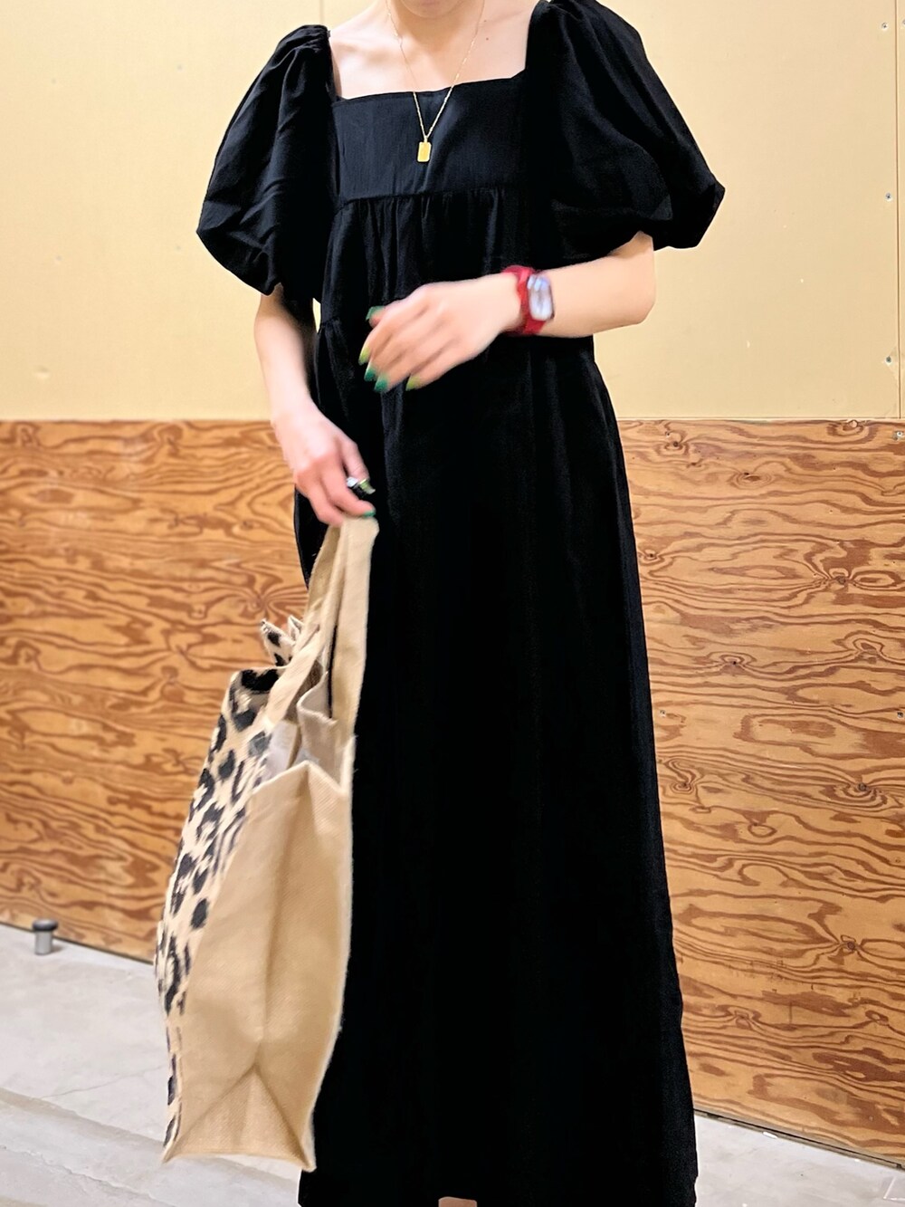 ブラック系のワンピース、ブラック系のトートバッグ、グレー系のサンダルを着用したレディースの春コーディネートの2枚目の写真