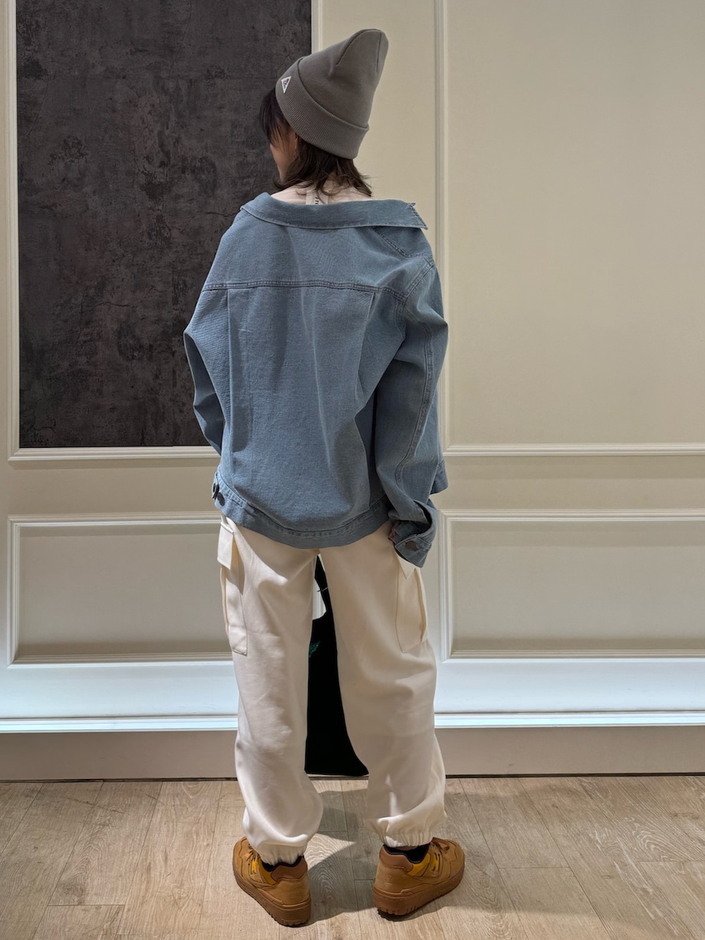 ブルー系のデニムジャケット、オレンジ系のトートバッグ、ホワイト系のカーゴパンツを着用したレディースの冬コーディネートの3枚目の写真