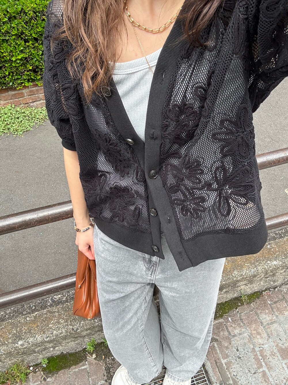 ブラック系のカーディガン/ボレロ、ベージュ系のデニムパンツを着用したレディースの春コーディネートの5枚目の写真