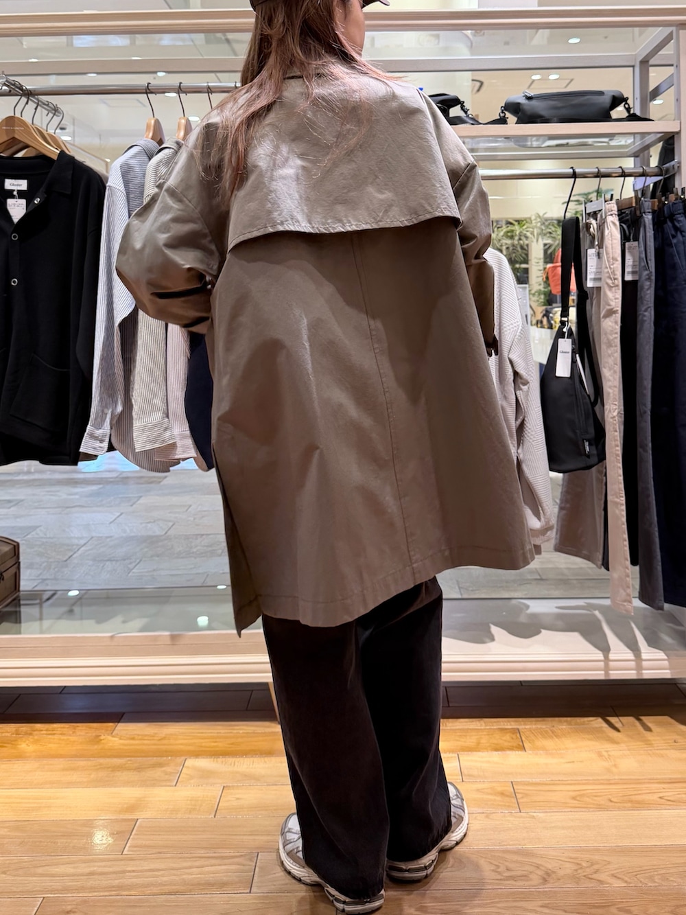 グリーン系のトレンチコート、ホワイト系のTシャツ/カットソー、ブルー系のデニムパンツを着用したレディースの春コーディネートの3枚目の写真