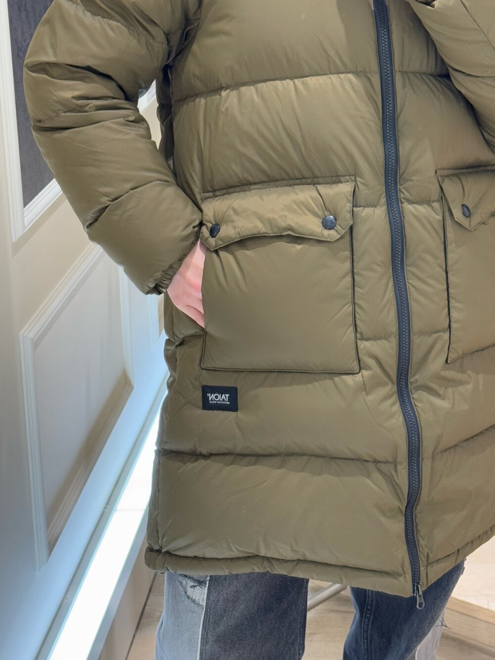 グリーン系のダウンジャケット/コート、ブルー系のキャップを着用したレディースの冬コーディネートの3枚目の写真