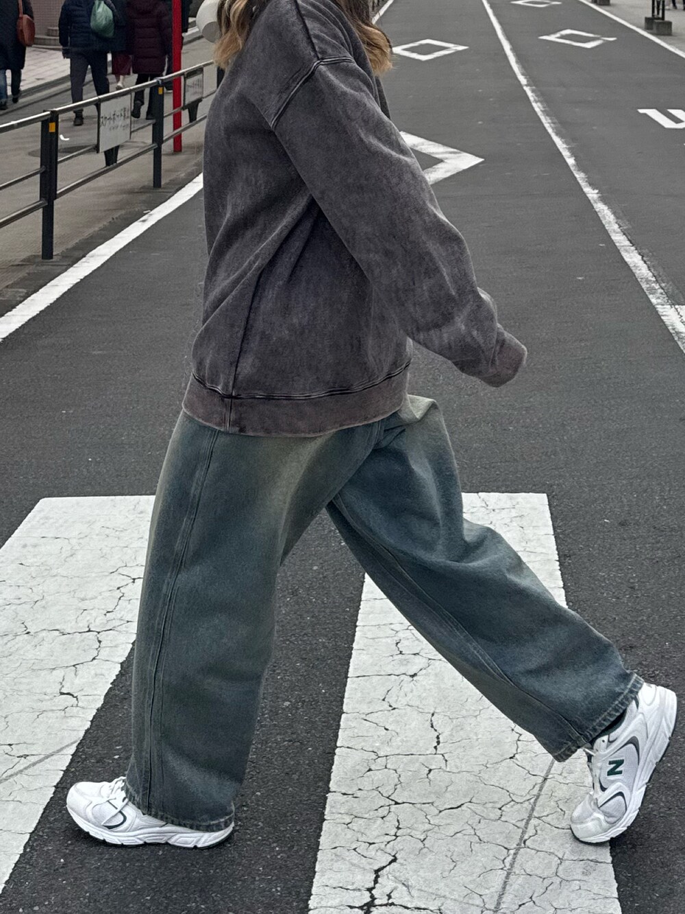 ブラック系のスウェット、ブルー系のデニムパンツを着用したレディースの冬コーディネートの2枚目の写真