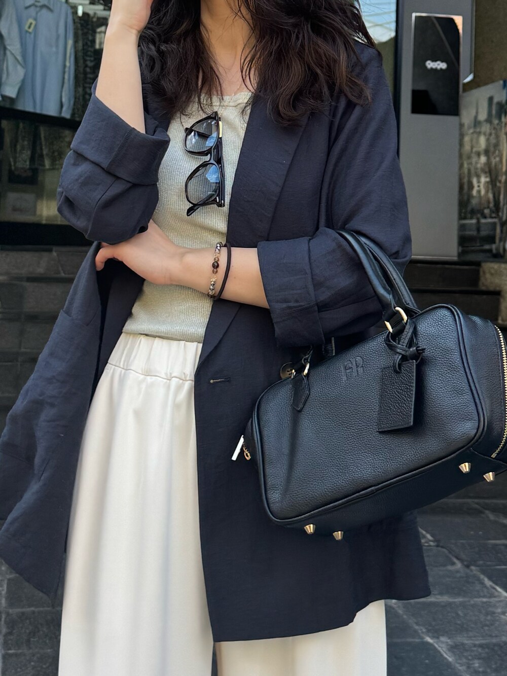 イエロー系のショルダーバッグ、ベージュ系のテーラードジャケット、ベージュ系のその他パンツを着用したレディースの春コーディネートの2枚目の写真