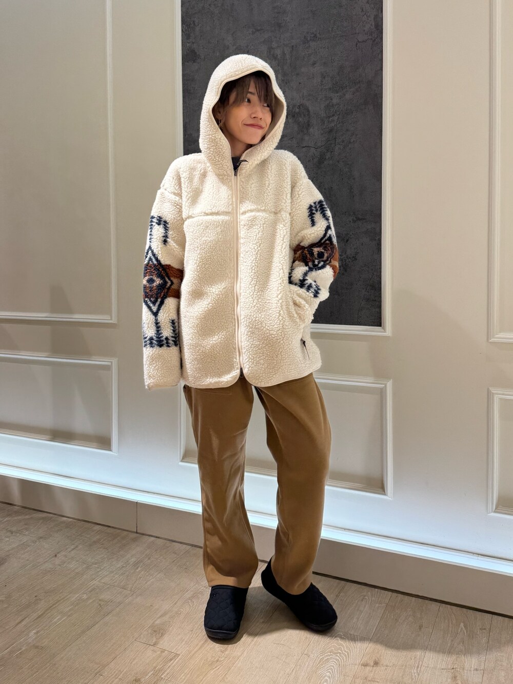 ホワイト系のブルゾン、ブラウン系のその他パンツ、ブラック系のサンダルを着用したレディースの秋コーディネートの3枚目の写真