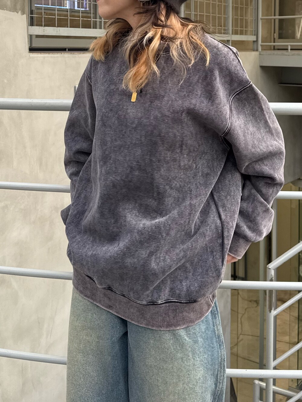 ブラック系のスウェット、ブルー系のデニムパンツを着用したレディースの冬コーディネートの3枚目の写真