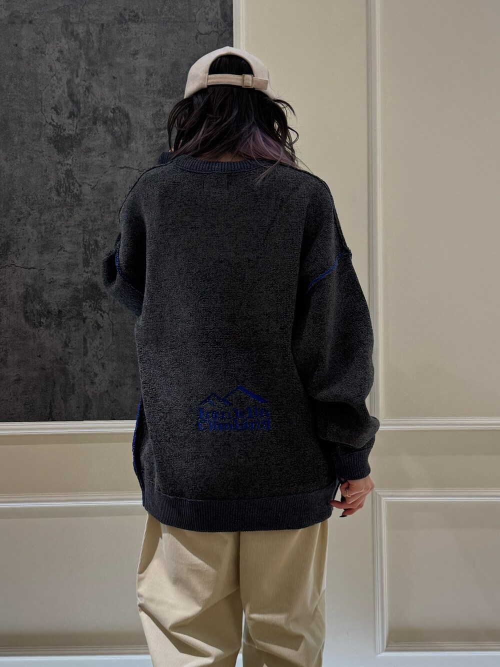 グレー系のニット/セーター、ホワイト系のその他パンツ、ブルー系のキャップを着用したレディースの秋コーディネートの4枚目の写真