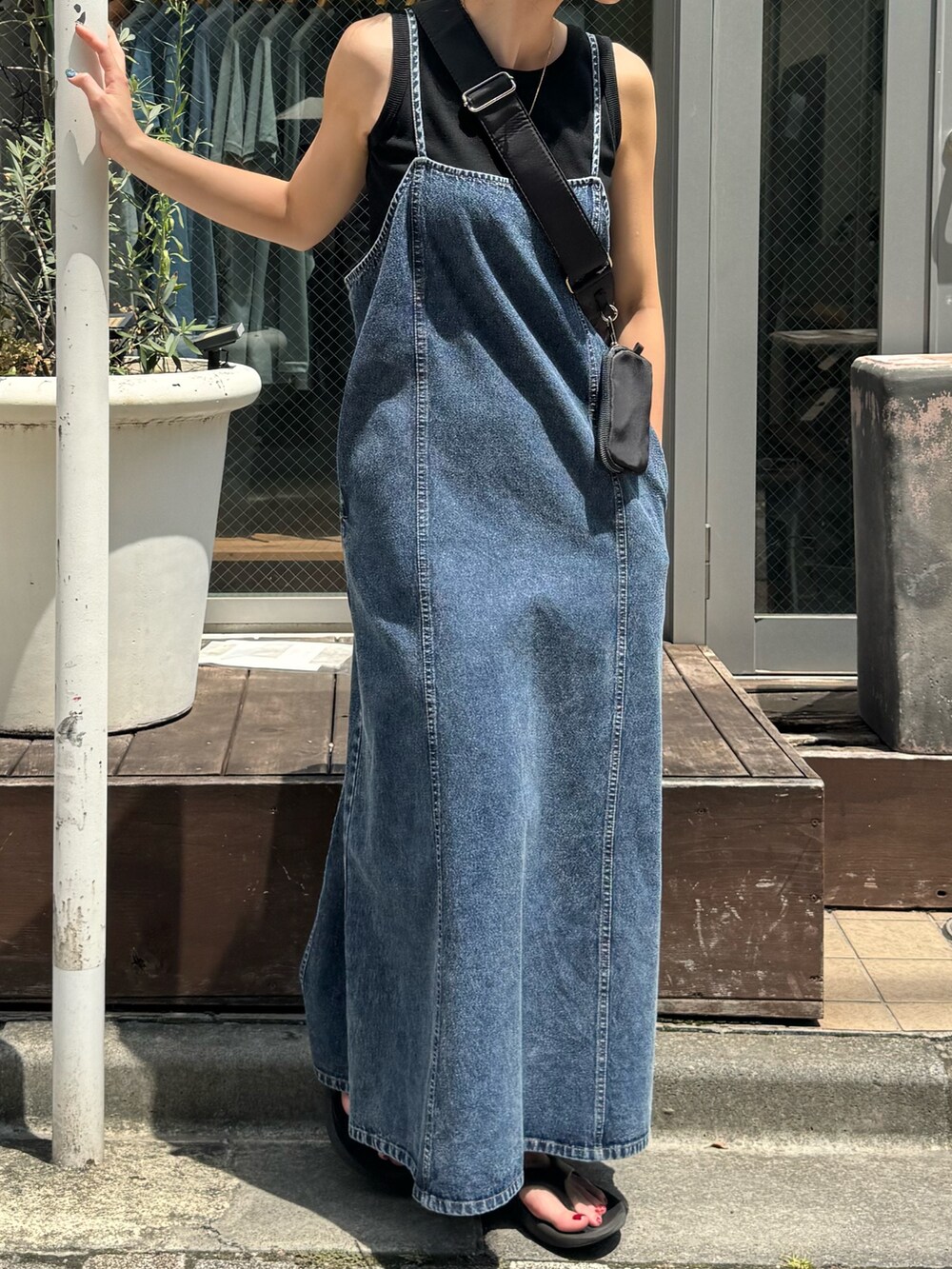 ブルー系のワンピース、ブラック系のショルダーバッグを着用したレディースの夏コーディネートの3枚目の写真