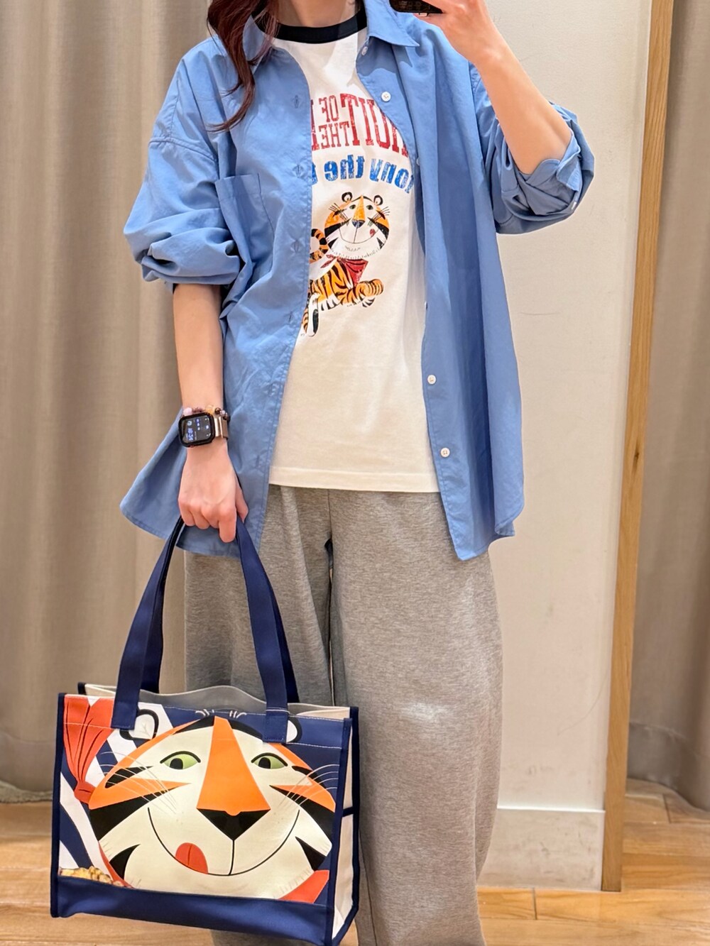 ブルー系のシャツ/ブラウス、ブルー系のトートバッグ、ホワイト系のTシャツ/カットソーを着用したレディースの春コーディネートの3枚目の写真