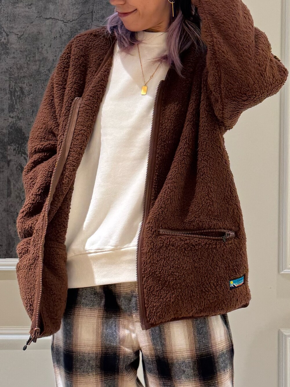 ブラウン系のカーディガン/ボレロ、ブルー系のキャップを着用したレディースの秋コーディネートの4枚目の写真