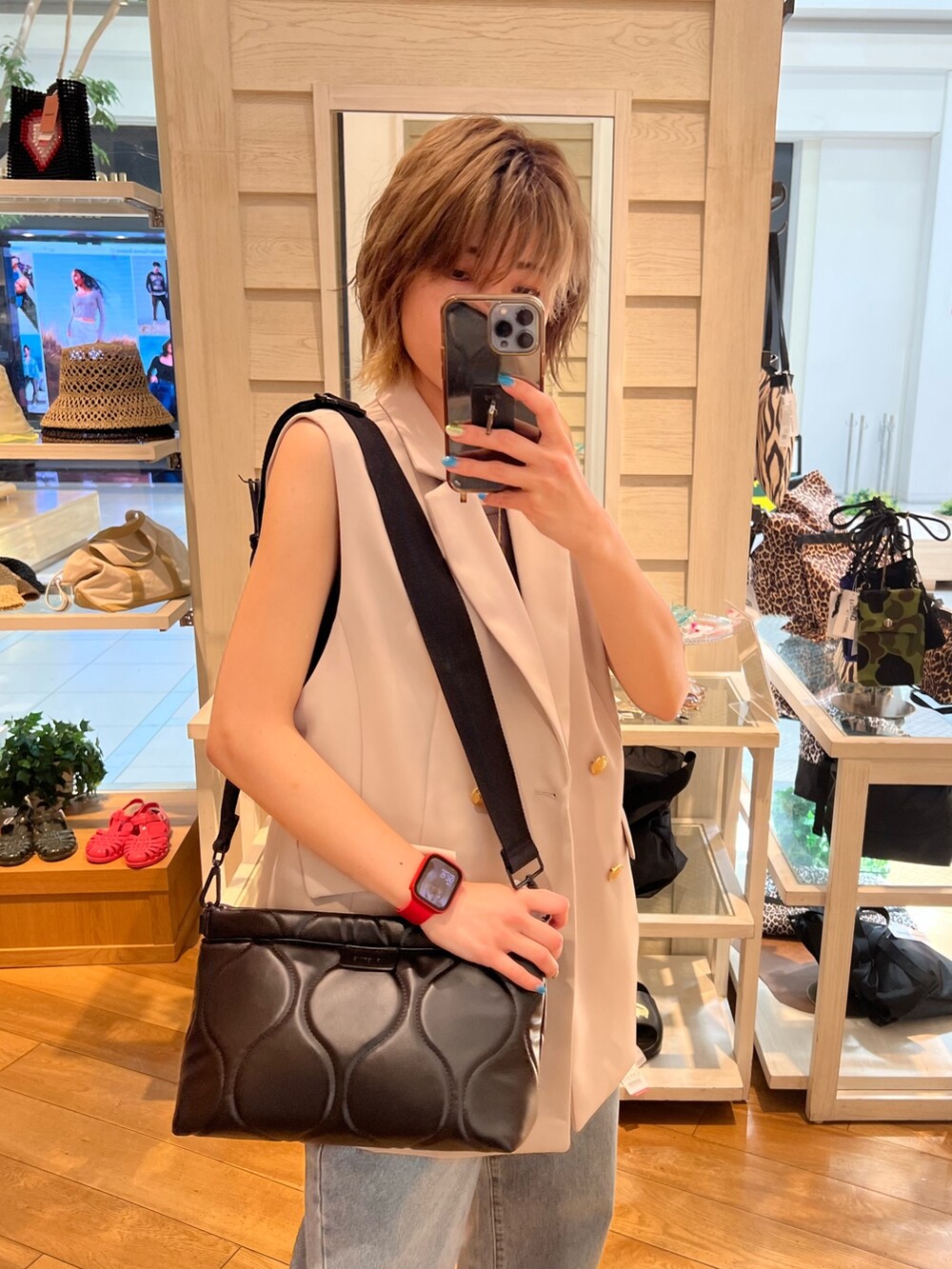 ブルー系のブルゾン、ブルー系のデニムパンツ、ブラック系のクラッチバッグを着用したレディースの夏コーディネートの3枚目の写真