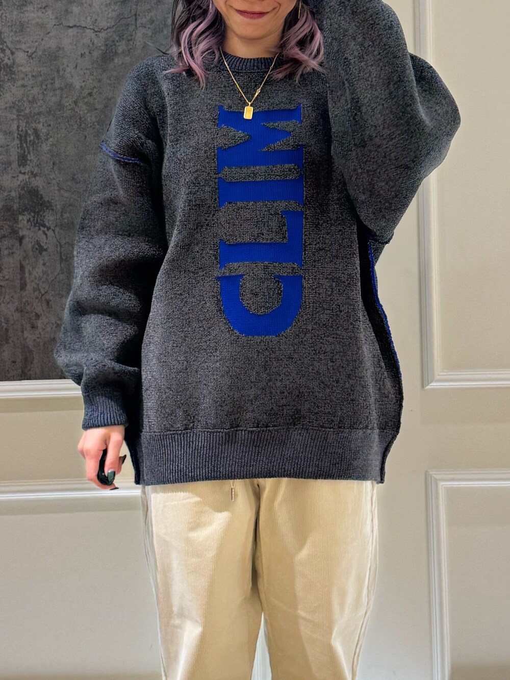 グレー系のニット/セーター、ホワイト系のその他パンツ、ブルー系のキャップを着用したレディースの秋コーディネートの2枚目の写真