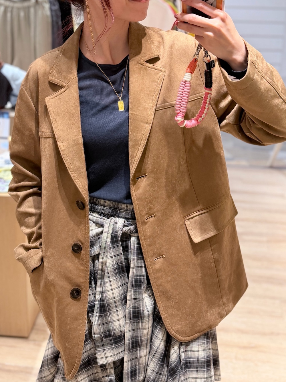 イエロー系のテーラードジャケット、ブルー系のTシャツ/カットソー、ホワイト系のスカートを着用したレディースの秋コーディネートの2枚目の写真