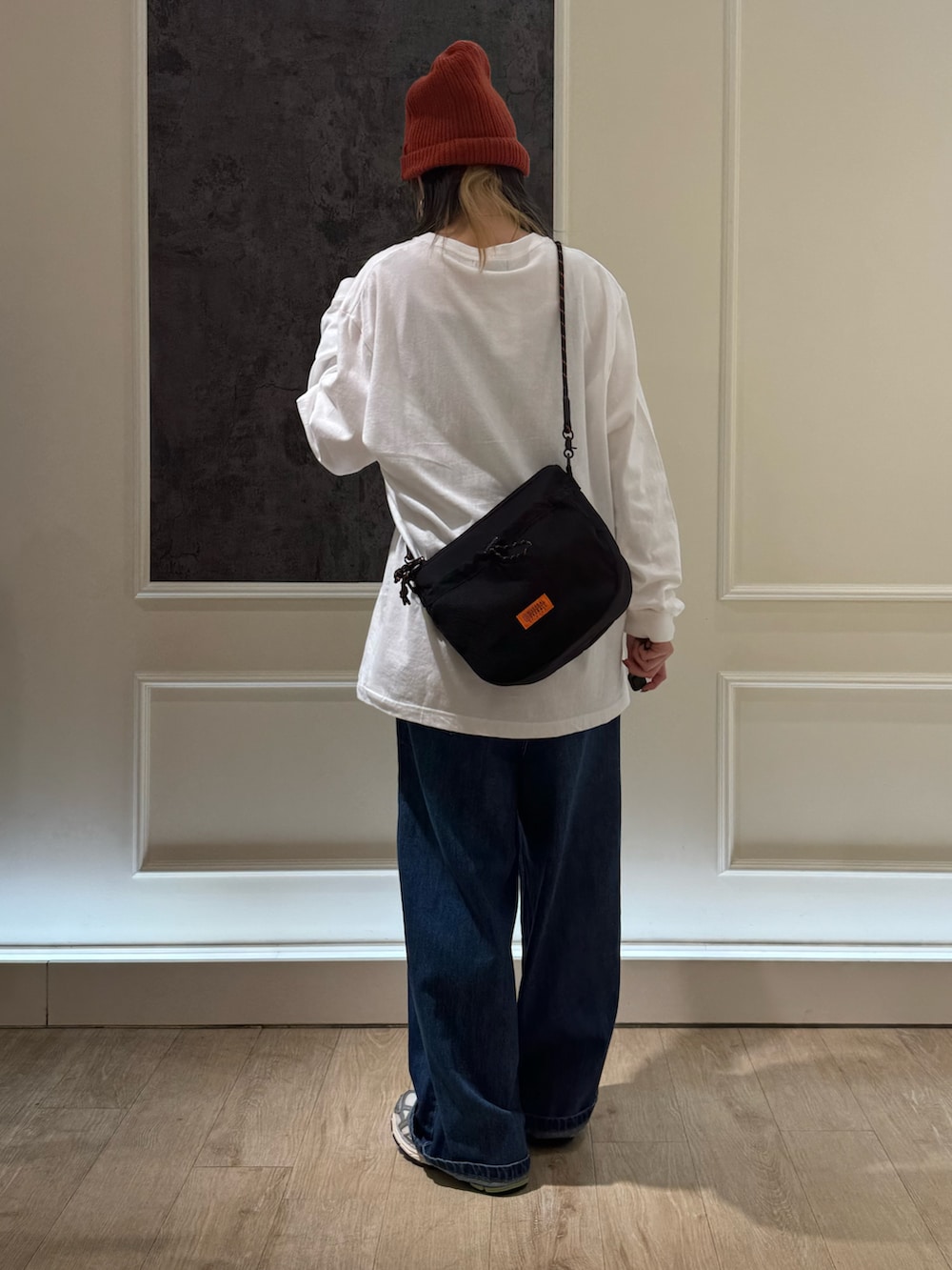 ホワイト系のTシャツ/カットソー、ブルー系のデニムパンツ、ブラック系のショルダーバッグを着用したレディースの秋コーディネートの4枚目の写真