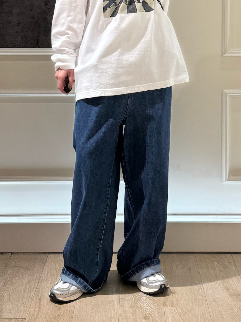 ホワイト系のTシャツ/カットソー、ブルー系のデニムパンツ、ブラック系のショルダーバッグを着用したレディースの秋コーディネートの6枚目の写真