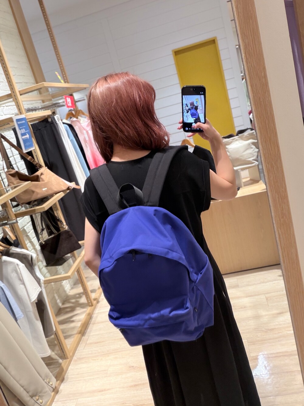 ブラック系のワンピース、ブルー系のバックパック/リュックを着用したレディースの夏コーディネートの3枚目の写真