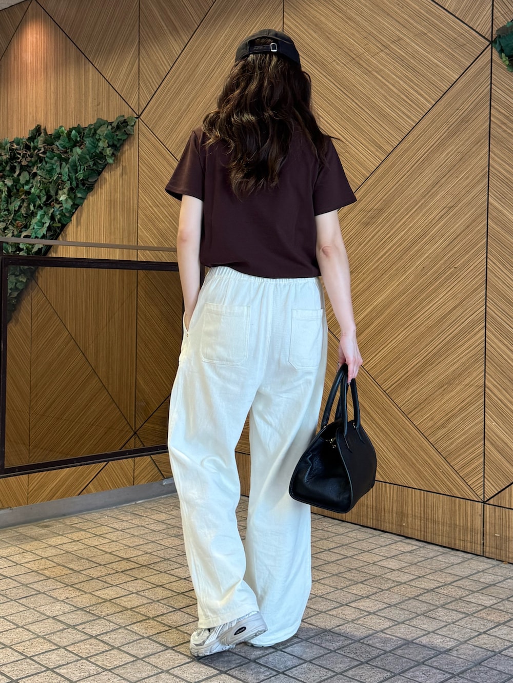 ブラウン系のTシャツ/カットソー、ホワイト系のデニムパンツ、ブラック系のショルダーバッグを着用したレディースの夏コーディネートの6枚目の写真