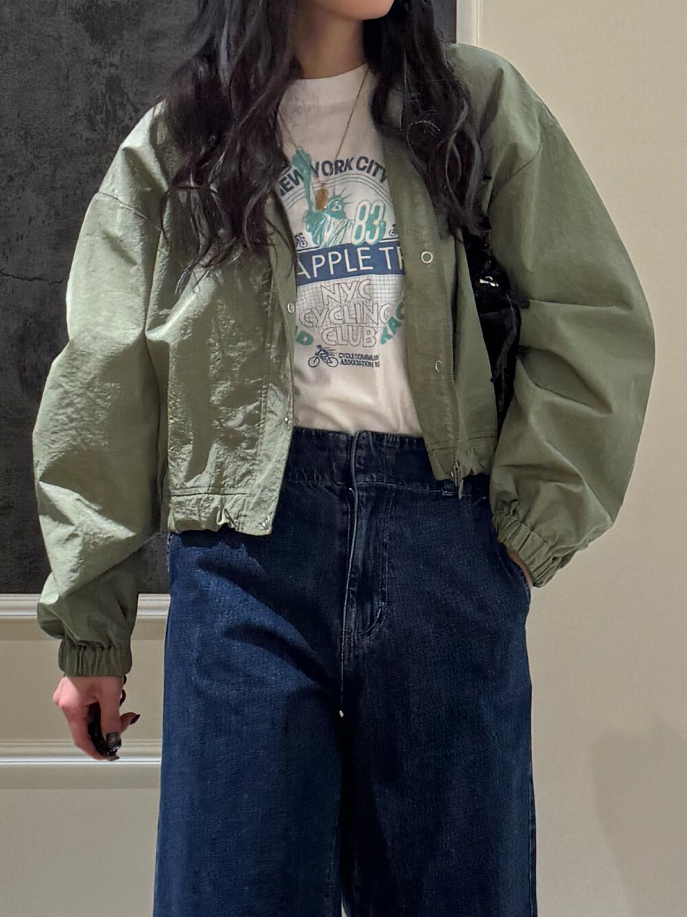 グリーン系のブルゾン、ブルー系のデニムパンツ、ホワイト系のTシャツ/カットソーを着用したレディースの春コーディネートの3枚目の写真