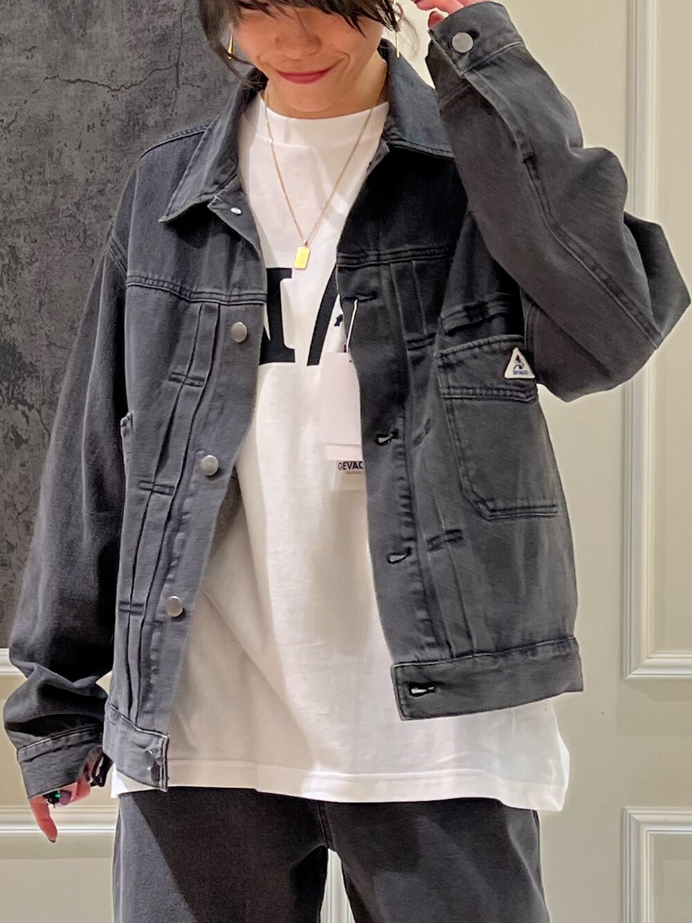 ブラック系のデニムジャケット、ブラック系のデニムパンツ、ホワイト系のTシャツ/カットソーを着用したレディースの秋コーディネートの2枚目の写真