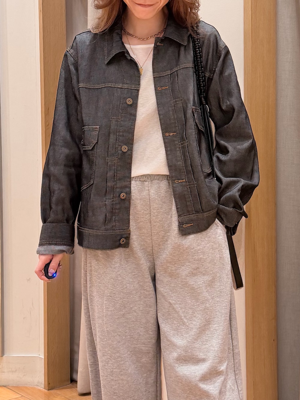 ブラック系のデニムジャケット、ブラック系のショルダーバッグを着用したレディースの春コーディネートの3枚目の写真