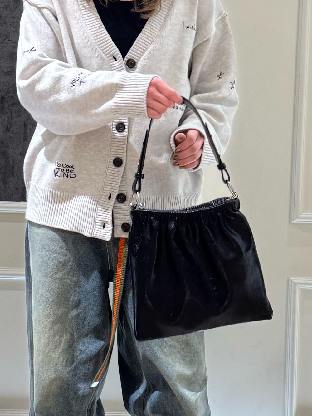ホワイト系のカーディガン/ボレロ、ブルー系のデニムパンツ、ブラック系のショルダーバッグを着用したレディースの冬コーディネートの3枚目の写真
