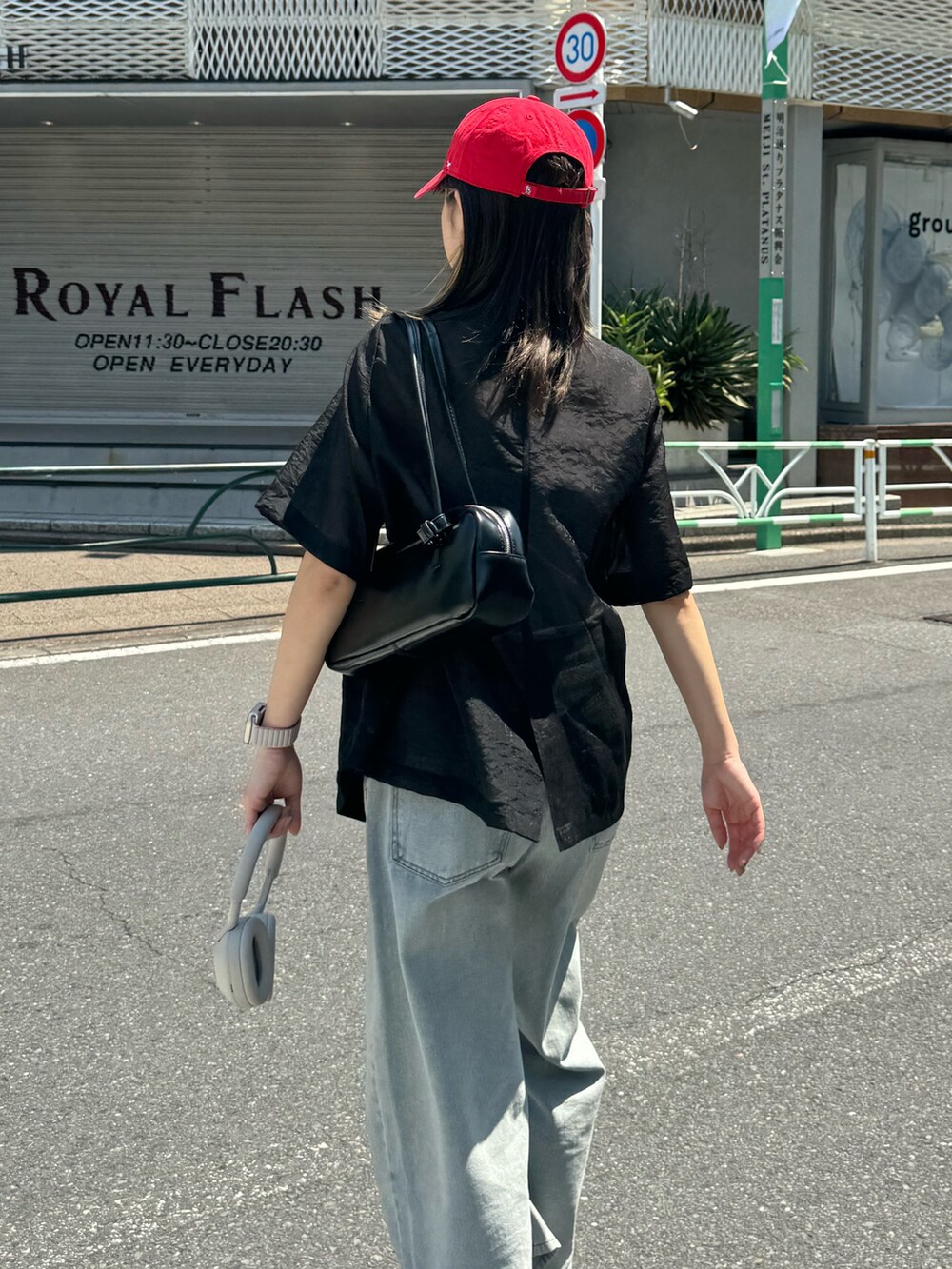 ブラック系のダウンジャケット/コート、ブルー系のデニムパンツ、ホワイト系のボストンバッグを着用したレディースの夏コーディネートの3枚目の写真