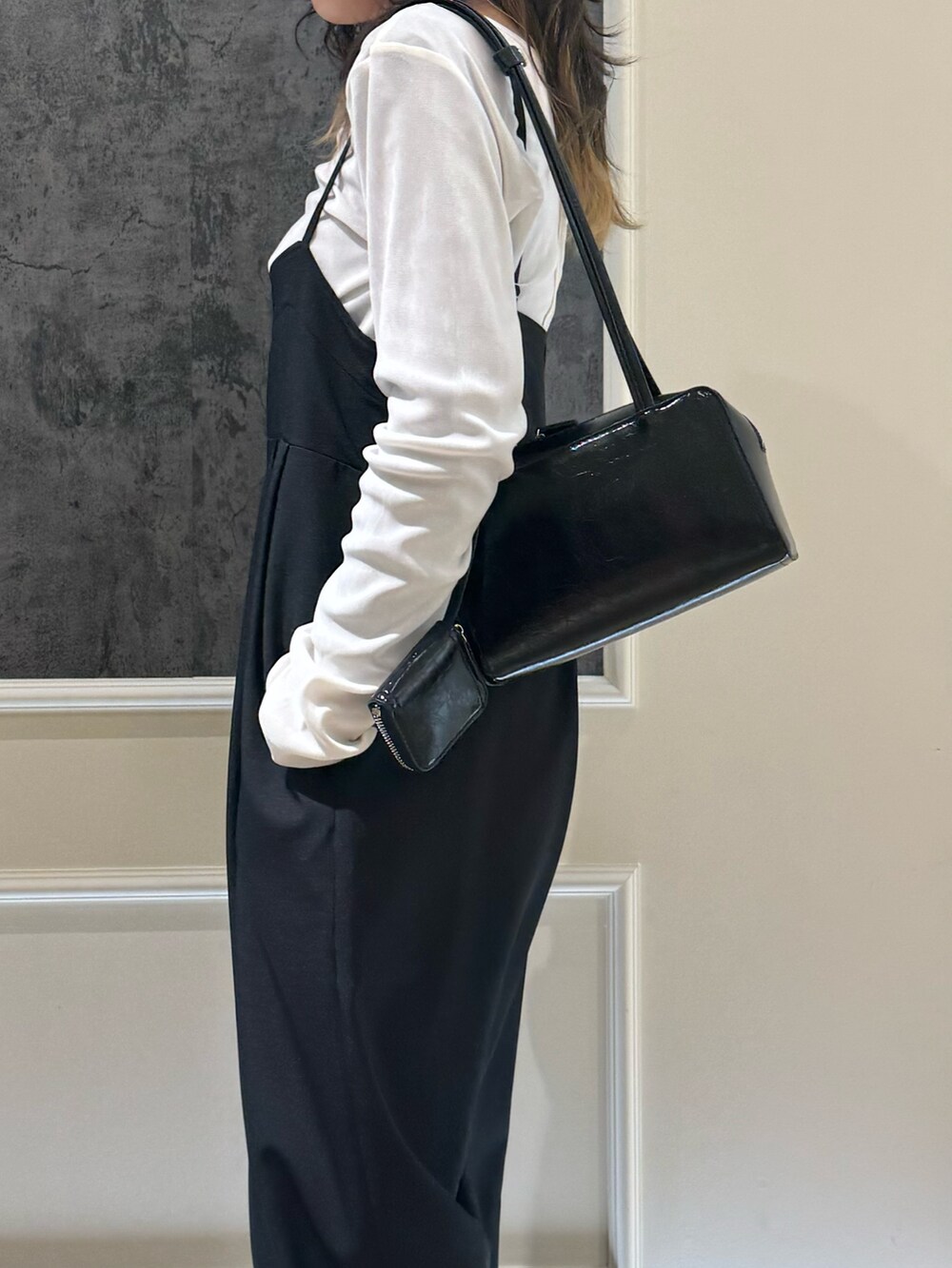 グレー系のTシャツ/カットソー、ブラック系のつなぎ/オールインワン、ブラウン系のボストンバッグを着用したレディースの春コーディネートの2枚目の写真