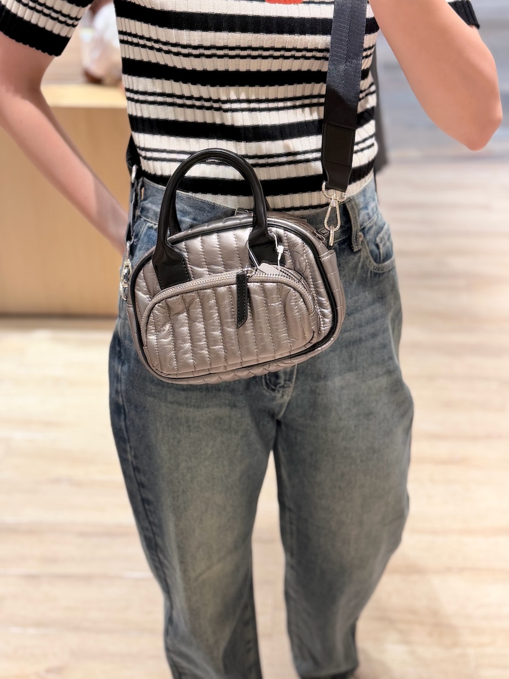 ブラウン系のニット/セーター、シルバー系のショルダーバッグを着用したレディースの夏コーディネートの2枚目の写真