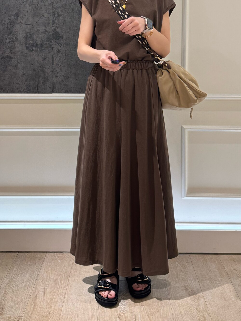 ブラウン系のTシャツ/カットソー、ブラウン系のスカート、ベージュ系のショルダーバッグを着用したレディースの夏コーディネートの5枚目の写真