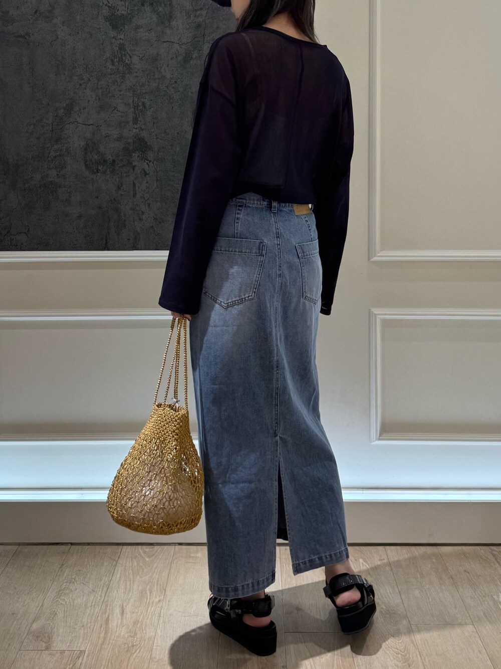 ブルー系のTシャツ/カットソー、ブルー系のデニムスカート、ブラック系のサンダルを着用したレディースの春コーディネートの4枚目の写真