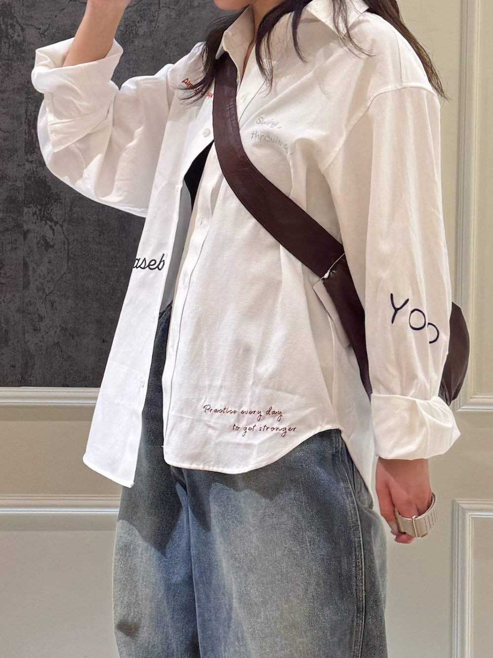 ホワイト系のシャツ/ブラウス、ブルー系のデニムパンツ、ブラウン系のショルダーバッグを着用したレディースの春コーディネートの3枚目の写真