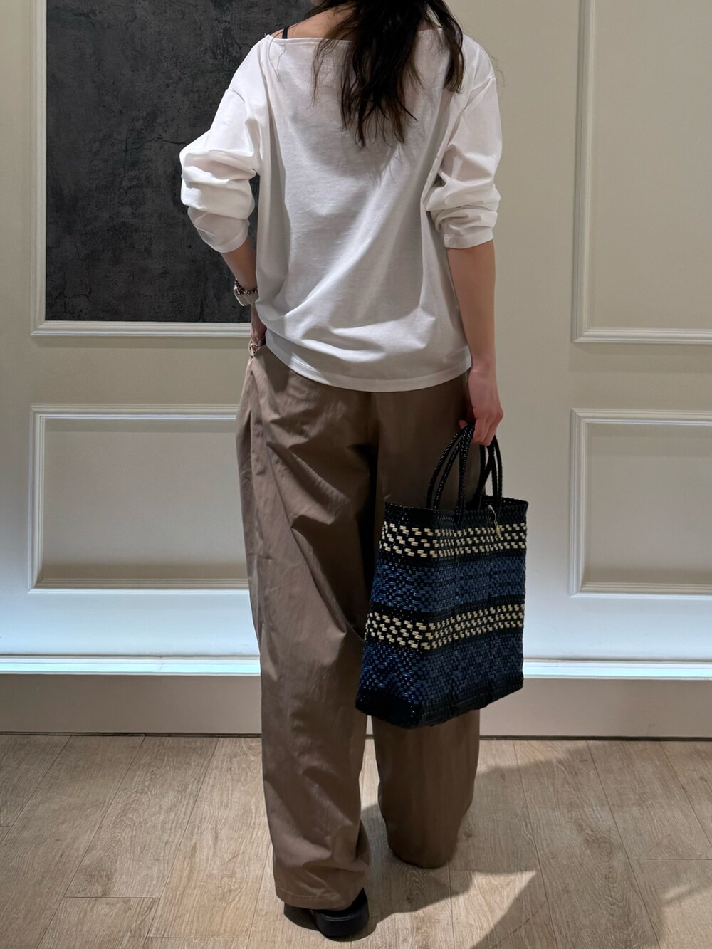 ホワイト系のTシャツ/カットソー、イエロー系のその他パンツ、ブラック系のサンダルを着用したレディースの春コーディネートの2枚目の写真