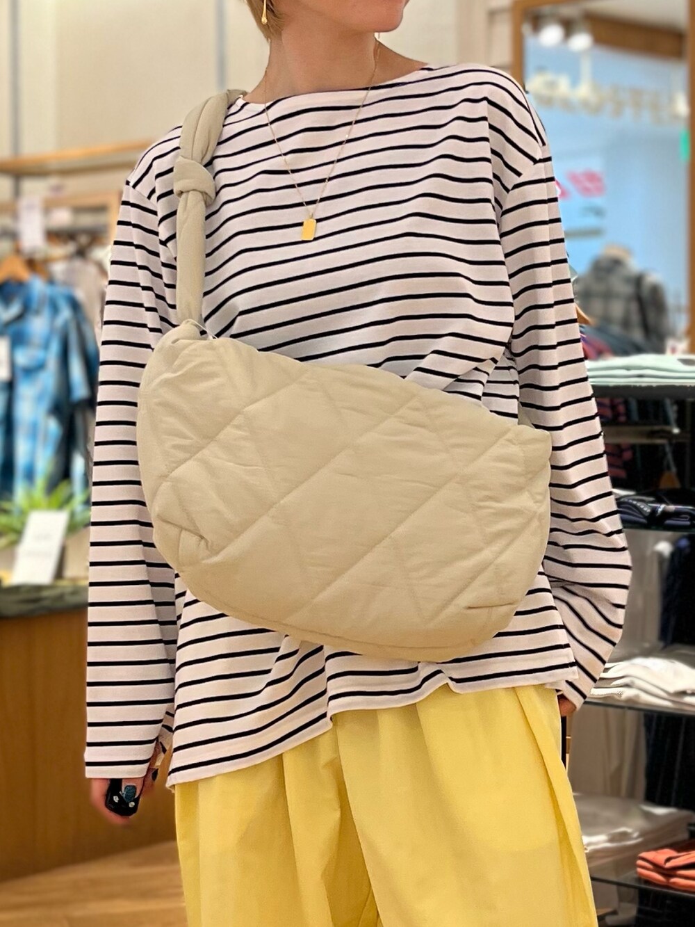 ホワイト系のTシャツ/カットソー、イエロー系のその他パンツ、ホワイト系のショルダーバッグを着用したレディースの春コーディネートの2枚目の写真