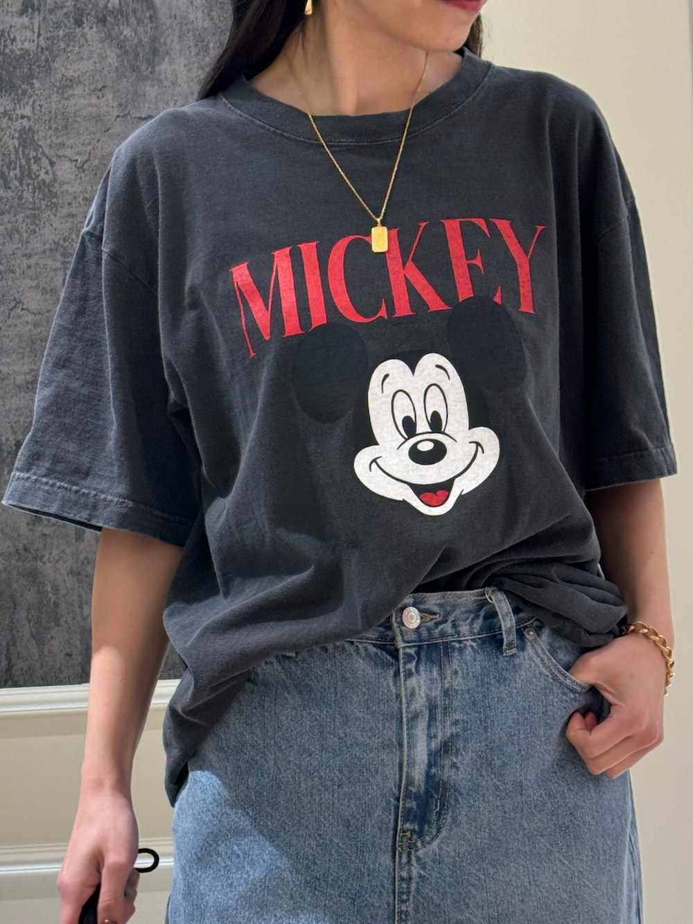 ブラック系のTシャツ/カットソー、ブラック系のデニムパンツ、グレー系のサンダルを着用したレディースの春コーディネートの4枚目の写真