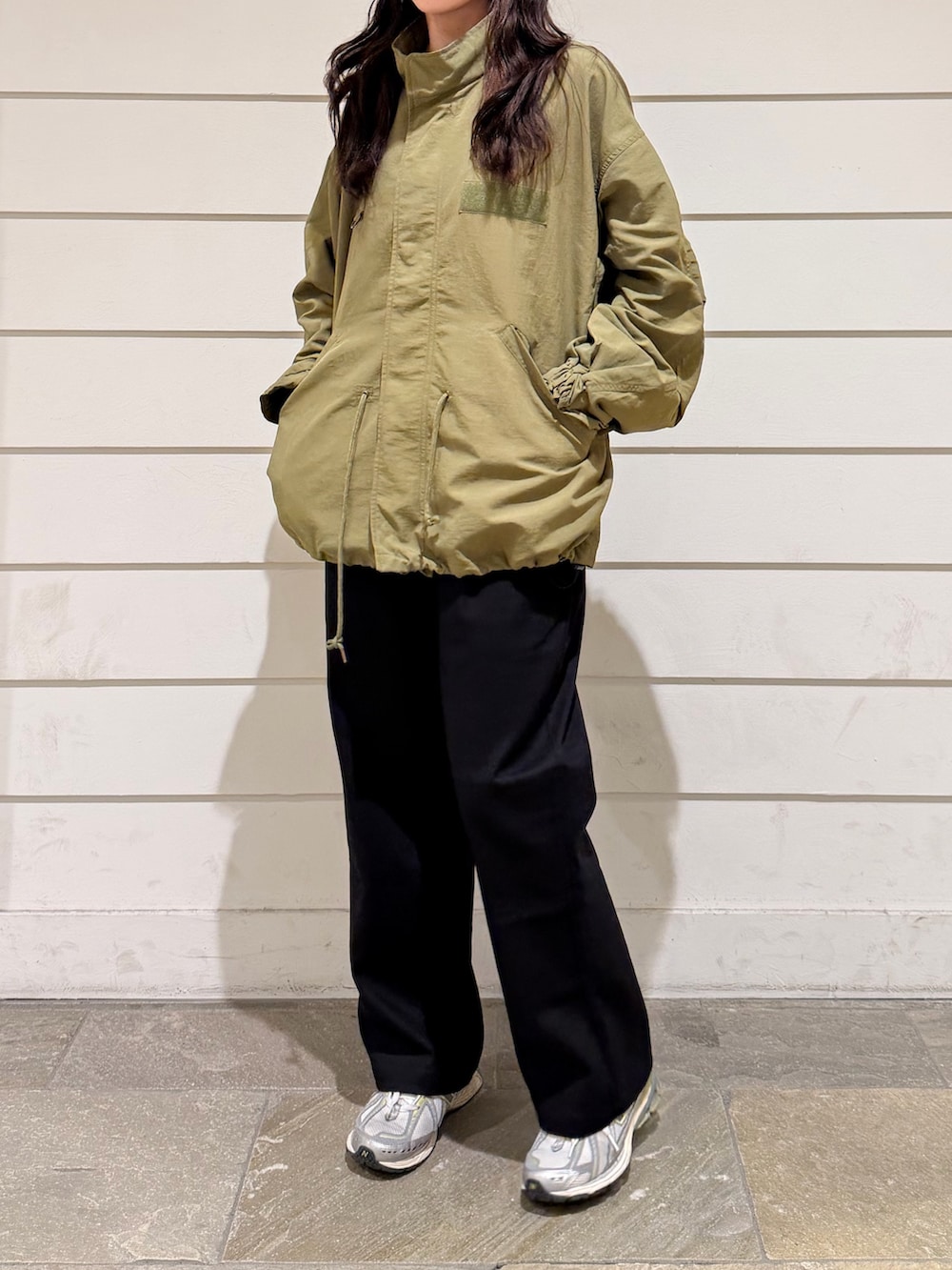 グリーン系のブルゾン、ブラック系のその他パンツ、ブラック系のキャップを着用したレディースの秋コーディネートの3枚目の写真