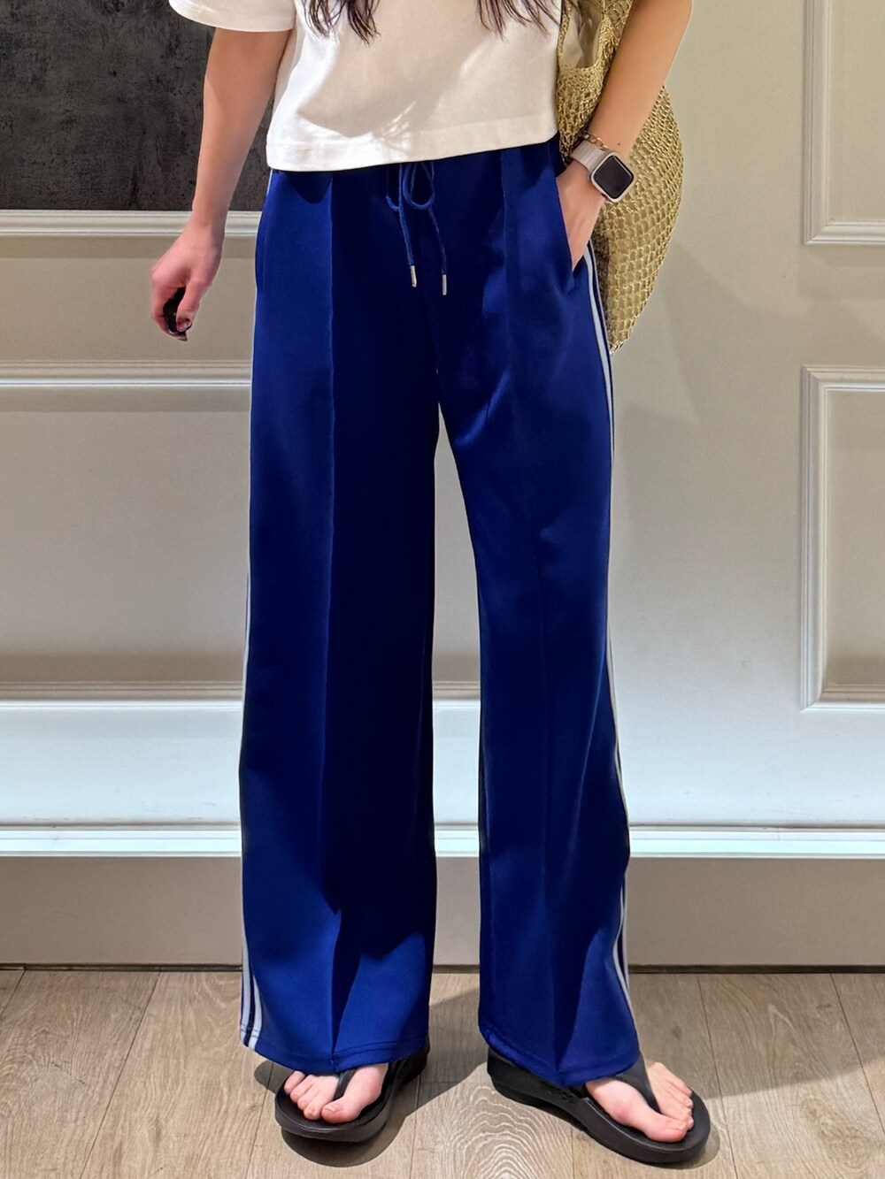 ホワイト系のTシャツ/カットソー、ホワイト系のその他パンツ、ゴールド系のトートバッグを着用したレディースの春コーディネートの3枚目の写真