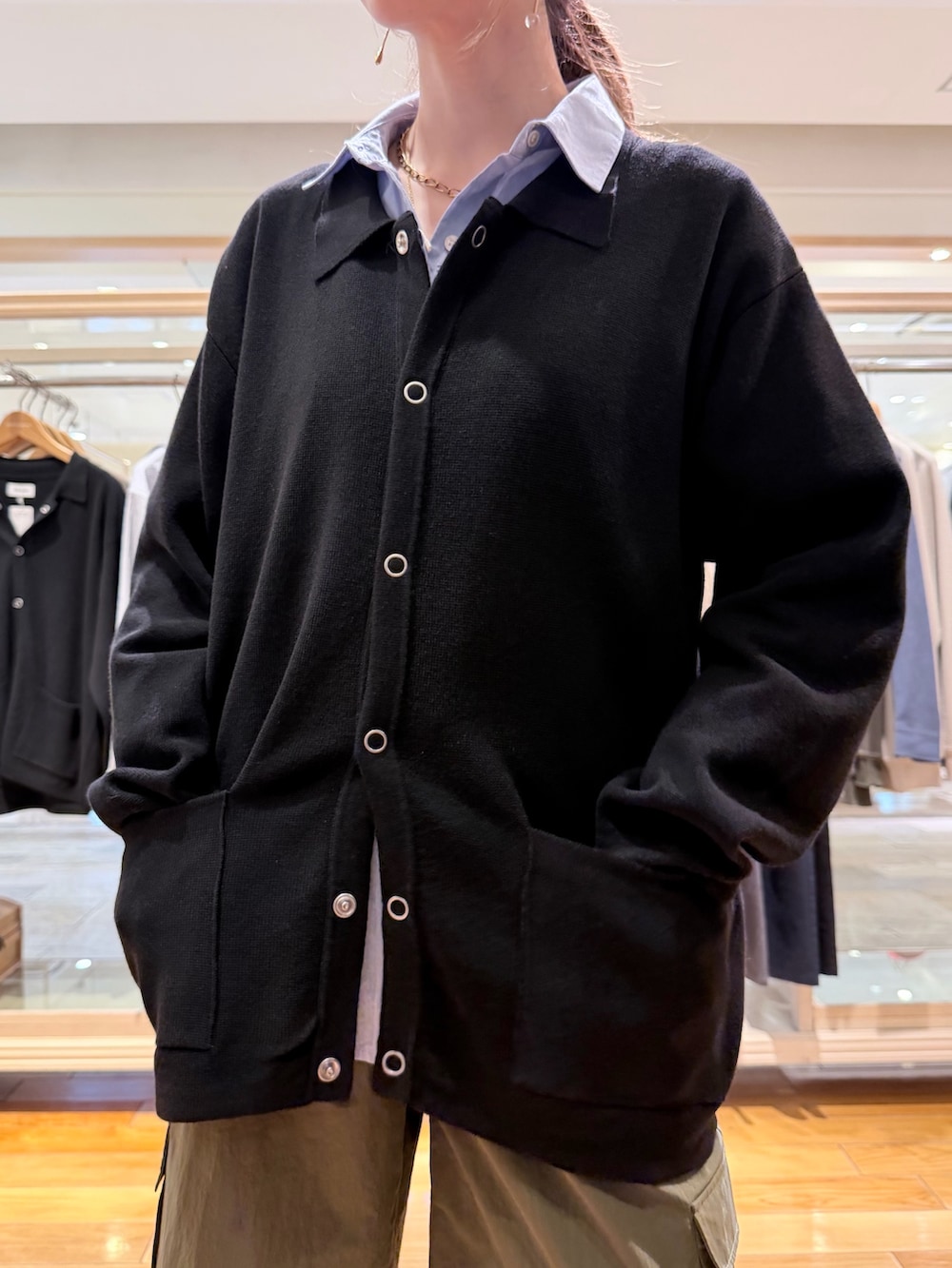 ブラック系のカーディガン/ボレロ、ブルー系のシャツ/ブラウス、グリーン系のカーゴパンツを着用したレディースの春コーディネートの3枚目の写真